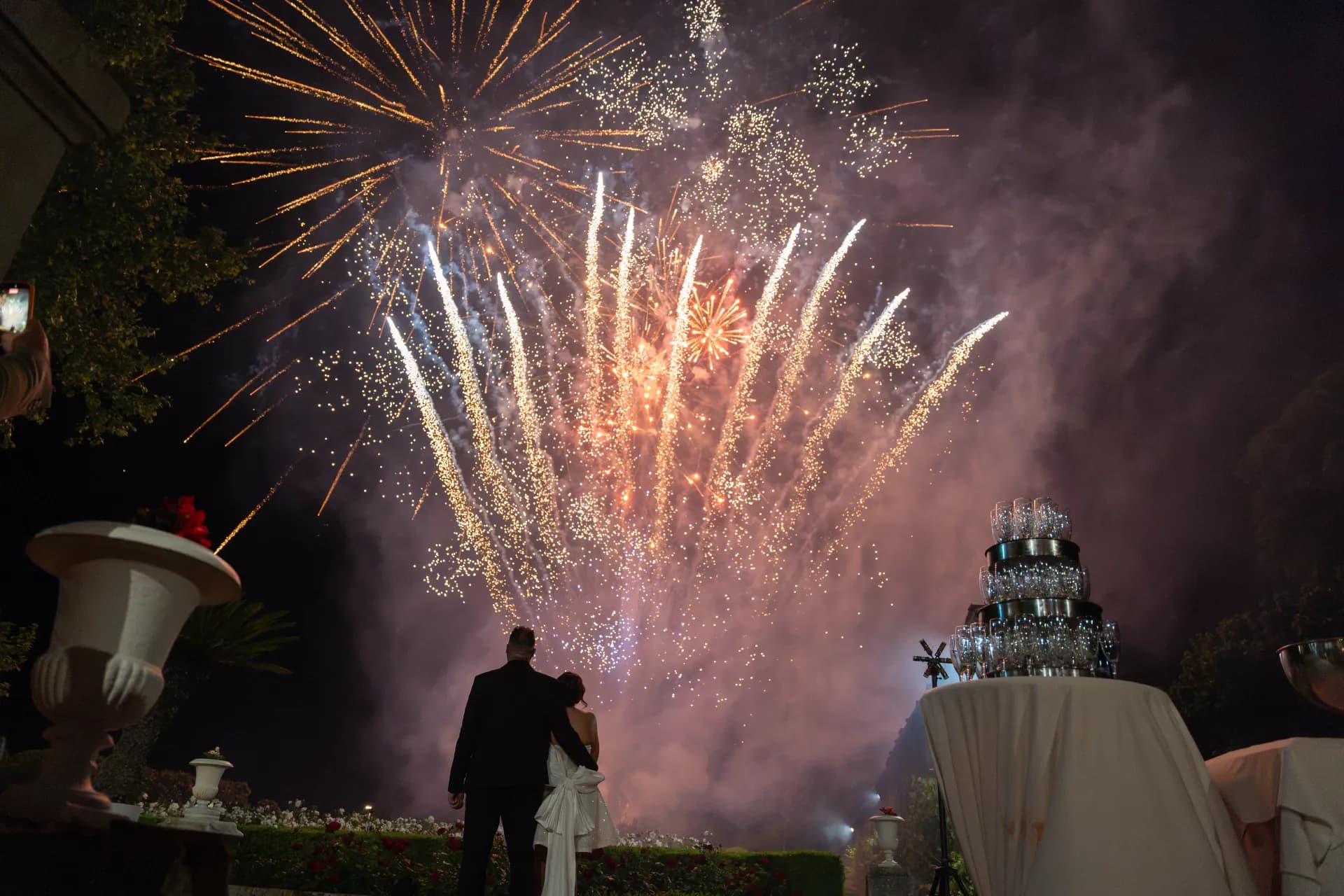 Feu d'artifice illuminant la façade du château pendant que les mariés découvrent leur pièce montée